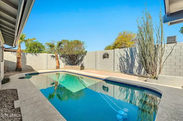 a view of a balcony with two plants and wooden fence
