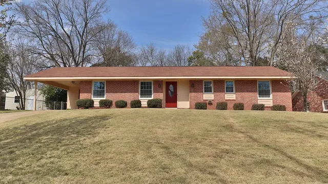 a front view of a building with a garden