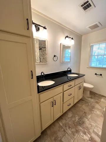 a spacious bathroom with a double vanity sink a large mirror and a bathtub