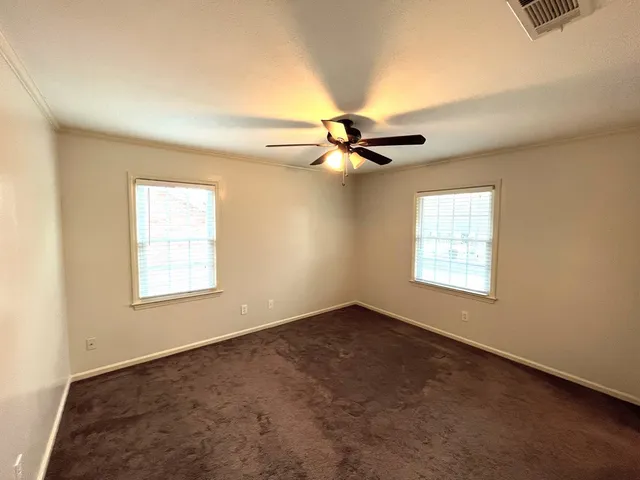 an empty room with a window and a fan