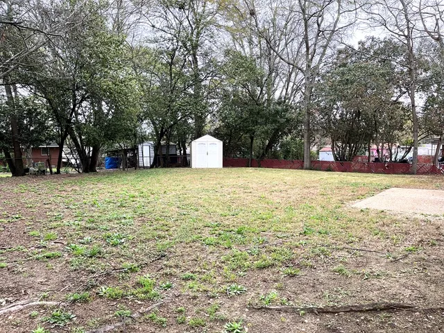 a view of a field with trees in the background