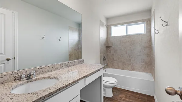 a bathroom with a granite countertop sink toilet and shower