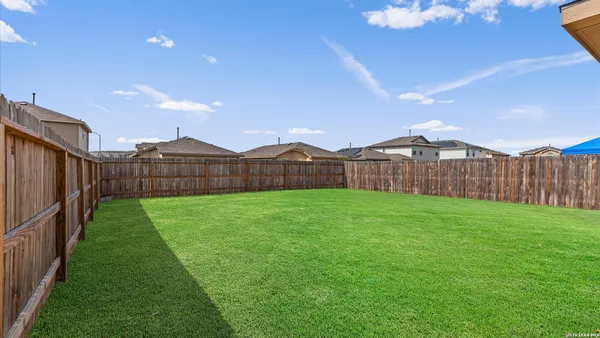 a view of a backyard with wooden fence