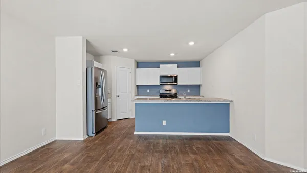a view of kitchen with stainless steel appliances granite countertop refrigerator sink and stove