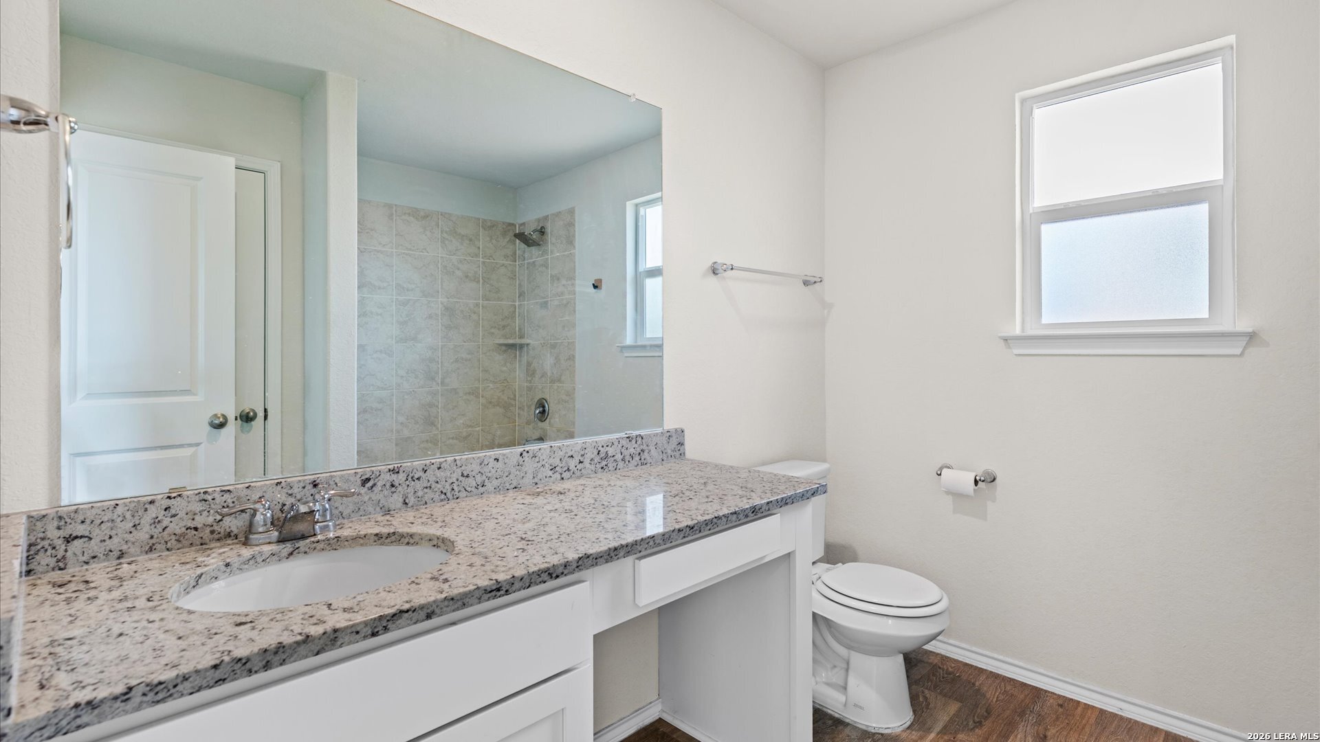 6819 Rondo Measure San Antonio, TX 78252 - Photo 9 of 25 a bathroom with a granite countertop sink a toilet and a mirror