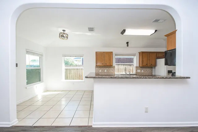 a view of a living room with granite countertop cabinets and a wooden floor