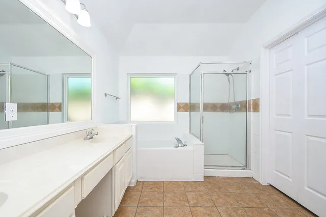 a bathroom with a tub sink and mirror