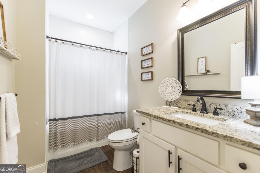 609 Live Oak Way Dublin, GA 31021 - Photo 28 of 37 a bathroom with a granite countertop sink toilet and shower