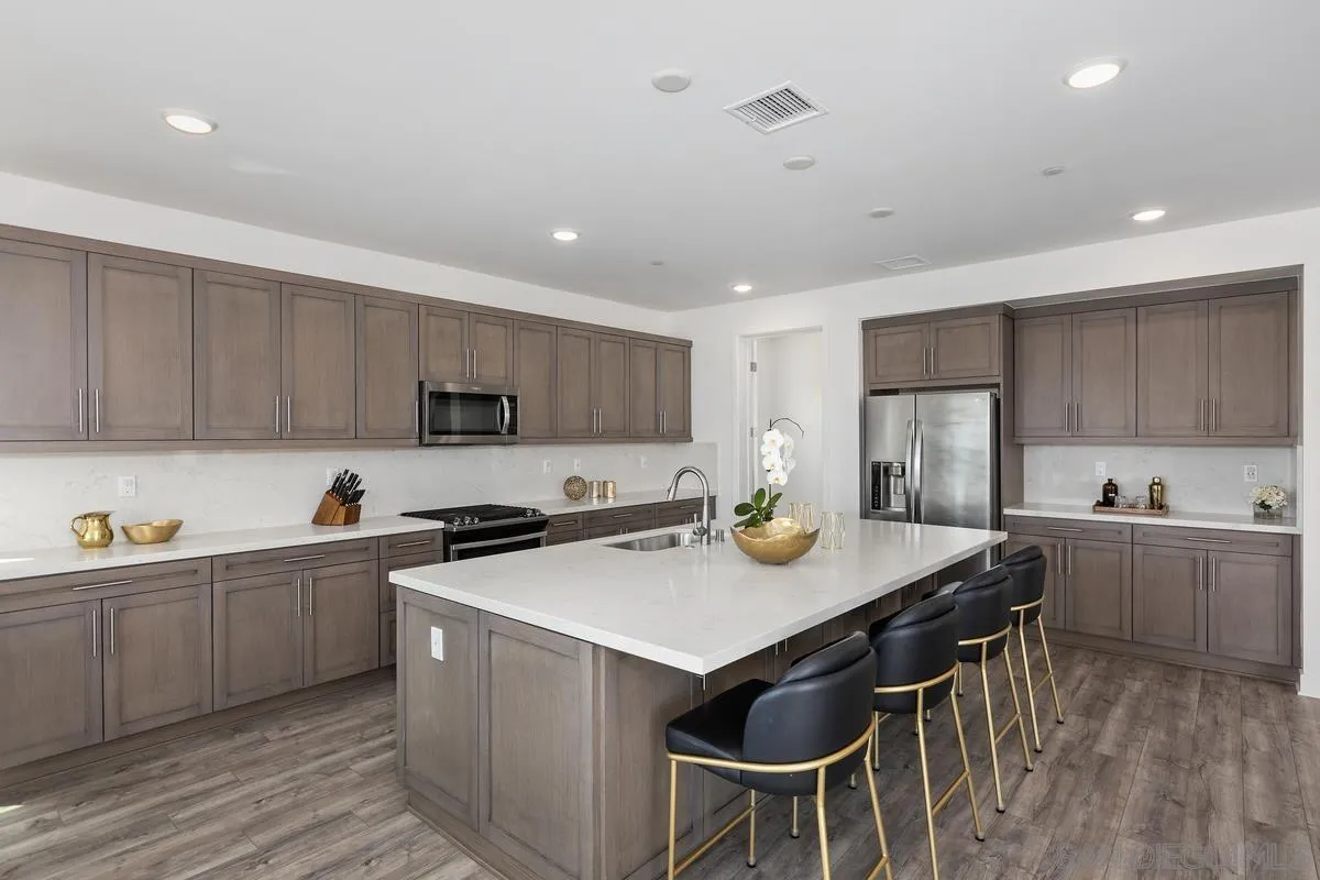8741 Weston Road Santee, CA 92071 - Photo 10 of 53 a kitchen with stainless steel appliances a sink a stove a table and chairs