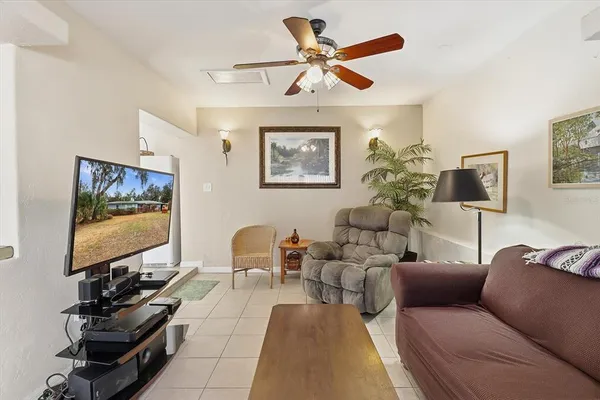 a living room with furniture a flat screen tv and a window