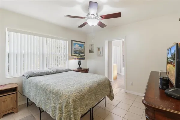 a bedroom with a bed and a flat tv screen on the dresser