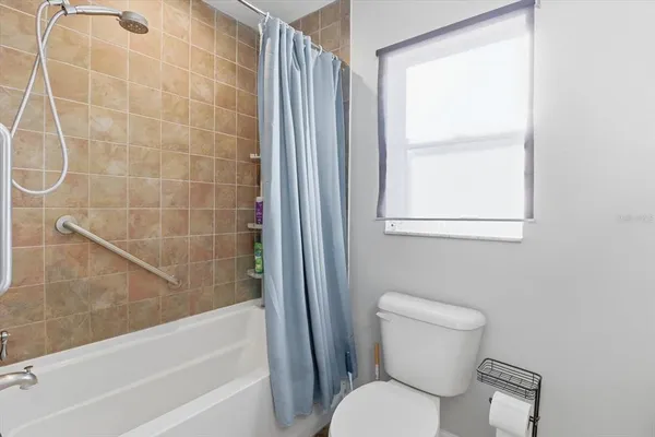 a white toilet sitting next to a bath tub