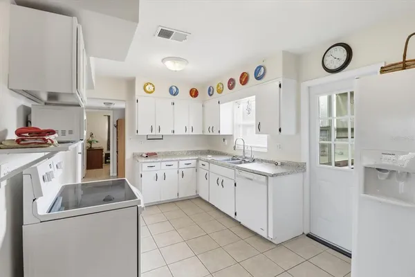a kitchen with granite countertop cabinets a sink and white stainless steel appliances