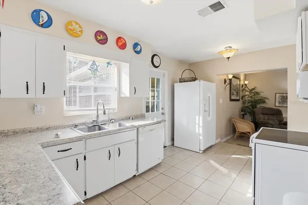 a kitchen with a sink a stove a refrigerator and a window