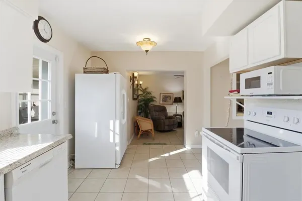 a kitchen with a refrigerator and white cabinets