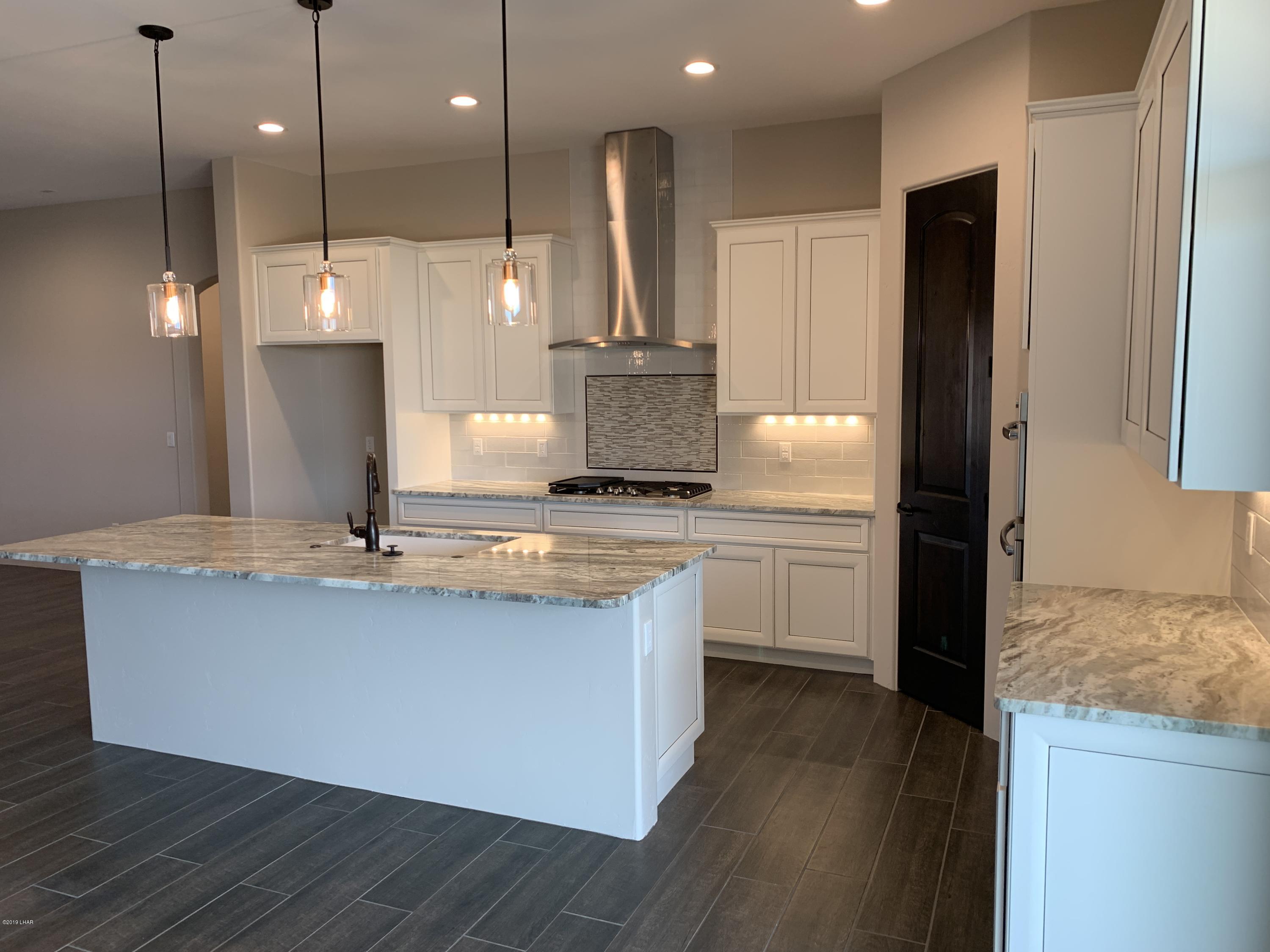4731 North Juneberry Road Lake Havasu City, AZ 86404 - Photo 12 of 52 a kitchen with kitchen island a counter top space a sink a stove and refrigerator
