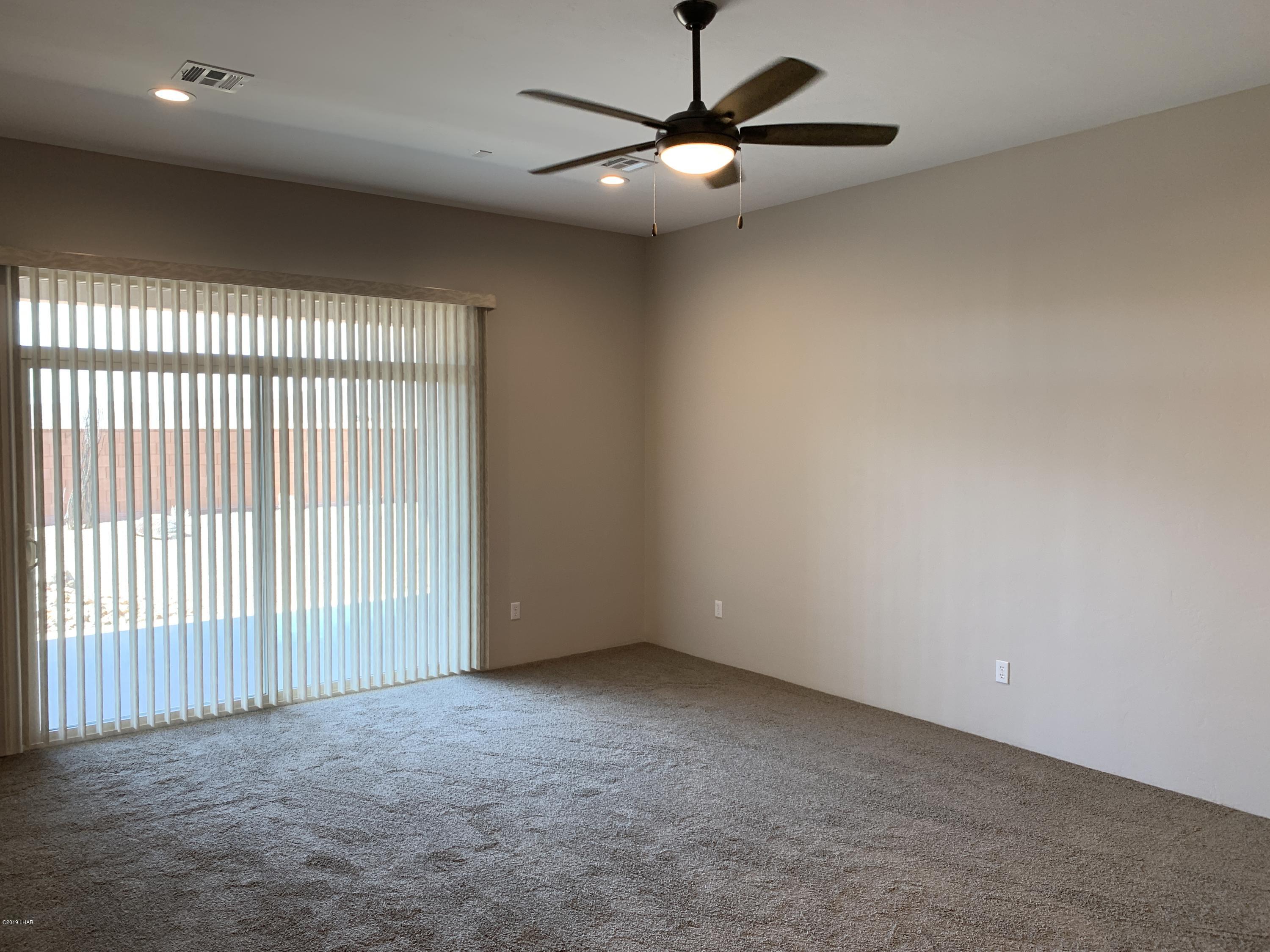 4731 North Juneberry Road Lake Havasu City, AZ 86404 - Photo 22 of 52 an empty room with a ceiling fan and a ceiling fan