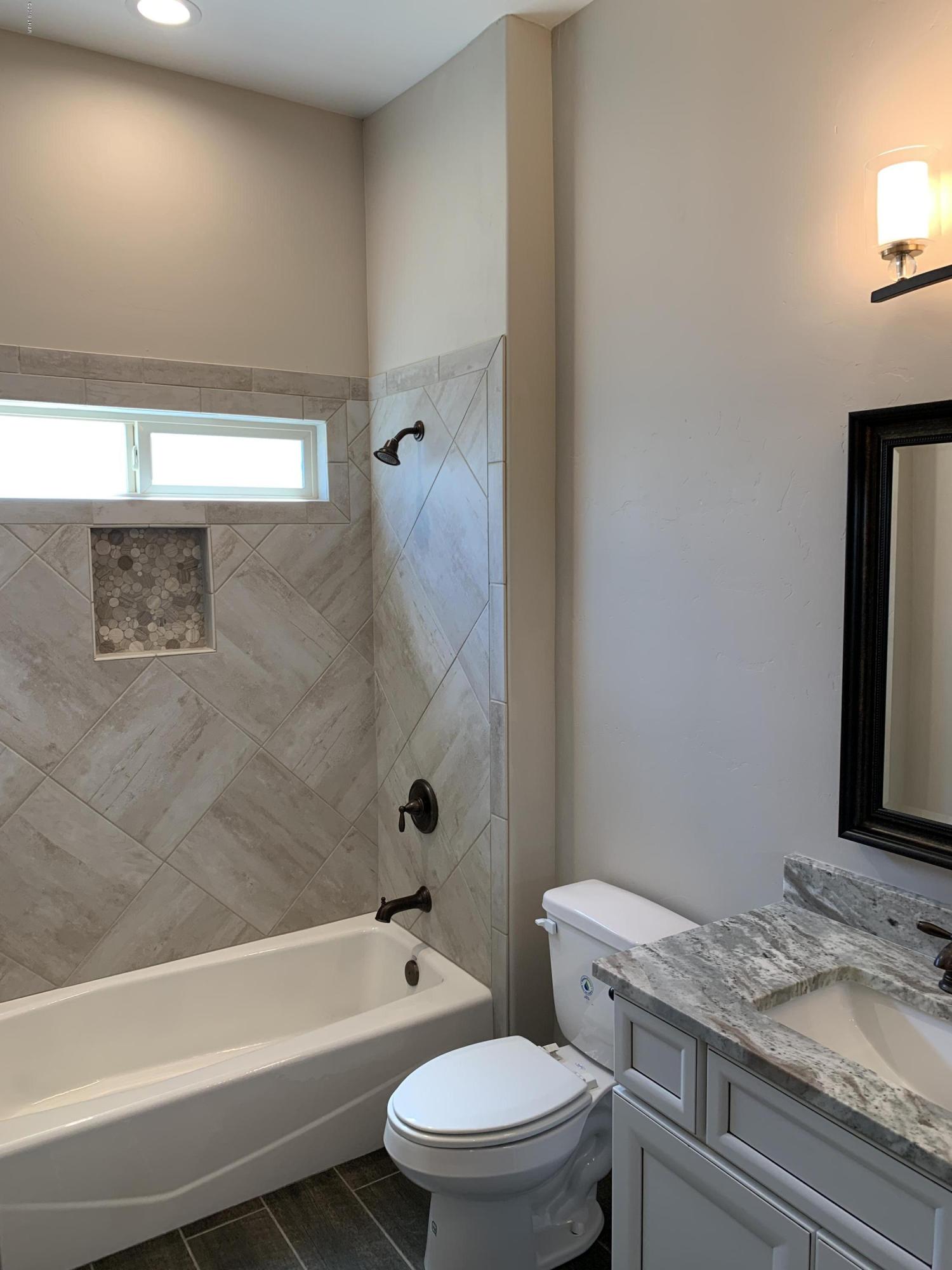 4731 North Juneberry Road Lake Havasu City, AZ 86404 - Photo 32 of 52 a bathroom with a granite countertop toilet a sink and bathtub