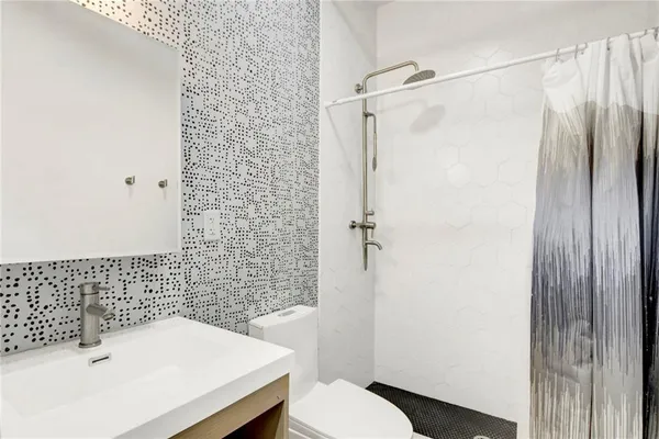 a bathroom with a sink toilet and shower
