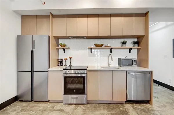 a kitchen with stainless steel appliances granite countertop a refrigerator sink and stove