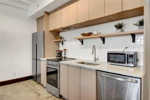 a kitchen with stainless steel appliances granite countertop a stove and a refrigerator