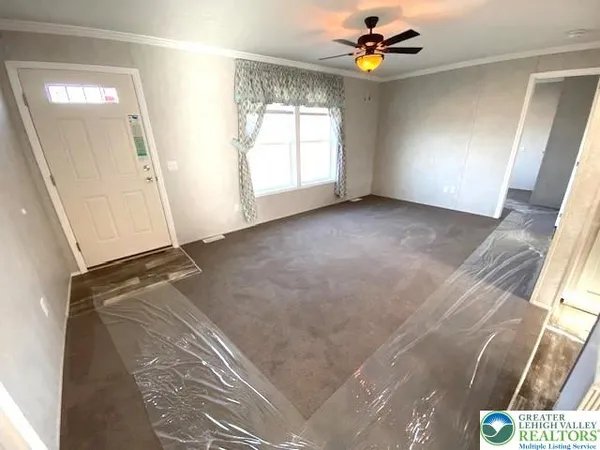 an empty room with windows and fan