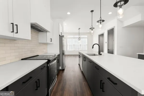 a kitchen with a sink appliances and cabinets