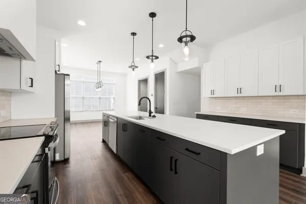 a kitchen with a sink and wooden floor