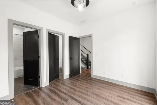 a view of a hallway with wooden floor and staircase in a kitchen