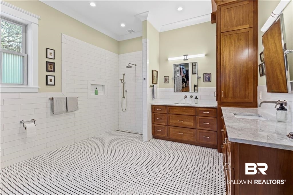 2730 Gator Road Mobile, AL 36605 - Photo 17 of 42 Bathroom featuring tile walls, a wainscoted wall, a walk in shower, two vanities, and light flooring