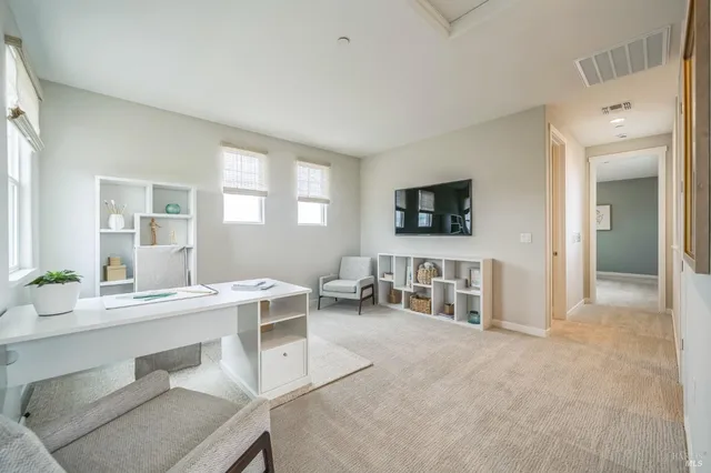 a kitchen with a dining table chairs and refrigerator