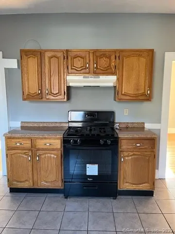 a kitchen with granite countertop a stove and cabinets