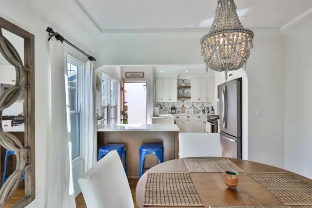 a kitchen with a stove a sink a dining table and chairs