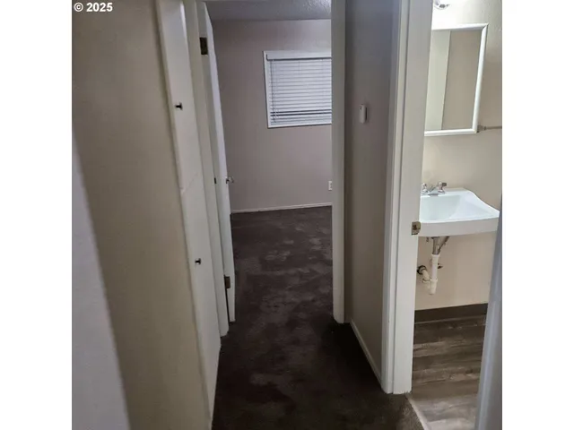 a view of a hallway with wooden floor