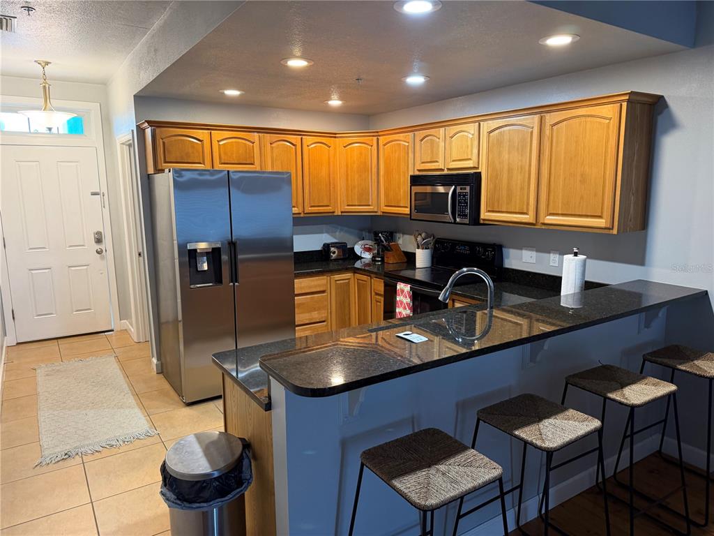 6990 Southwest Highway 358, Unit 2B Steinhatchee, FL 32359 - Photo 7 of 13 a kitchen with stainless steel appliances granite countertop a sink refrigerator and microwave