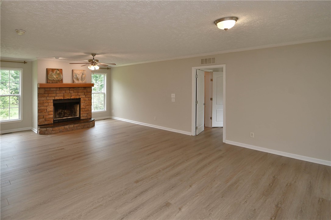 579 Daventon Road Honea Path, SC 29654 - Photo 17 of 44 A stone-clad fireplace and wood-look flooring define this welcoming living space.