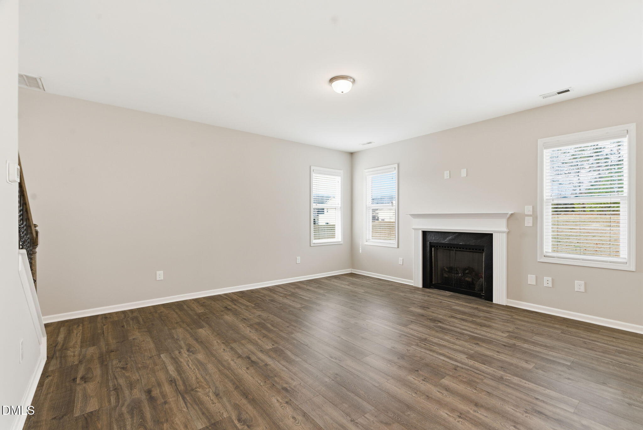 48 Weathervane Dr. Zebulon, NC 27597 - Photo 16 of 68 an empty room with wooden floor fireplace and windows