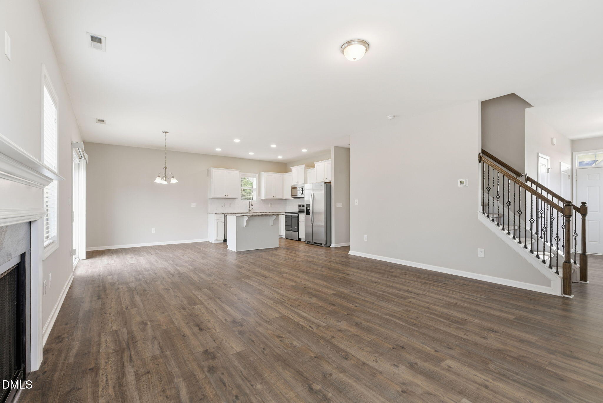 48 Weathervane Dr. Zebulon, NC 27597 - Photo 17 of 68 a view of an empty room with wooden floor and a kitchen