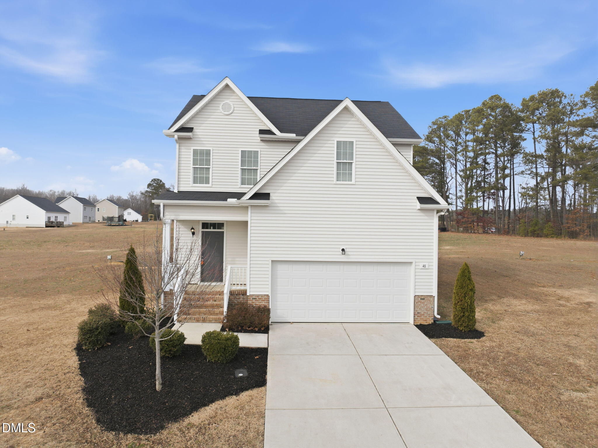 48 Weathervane Dr. Zebulon, NC 27597 - Photo 3 of 68 a view of a white house next to a yard and lake