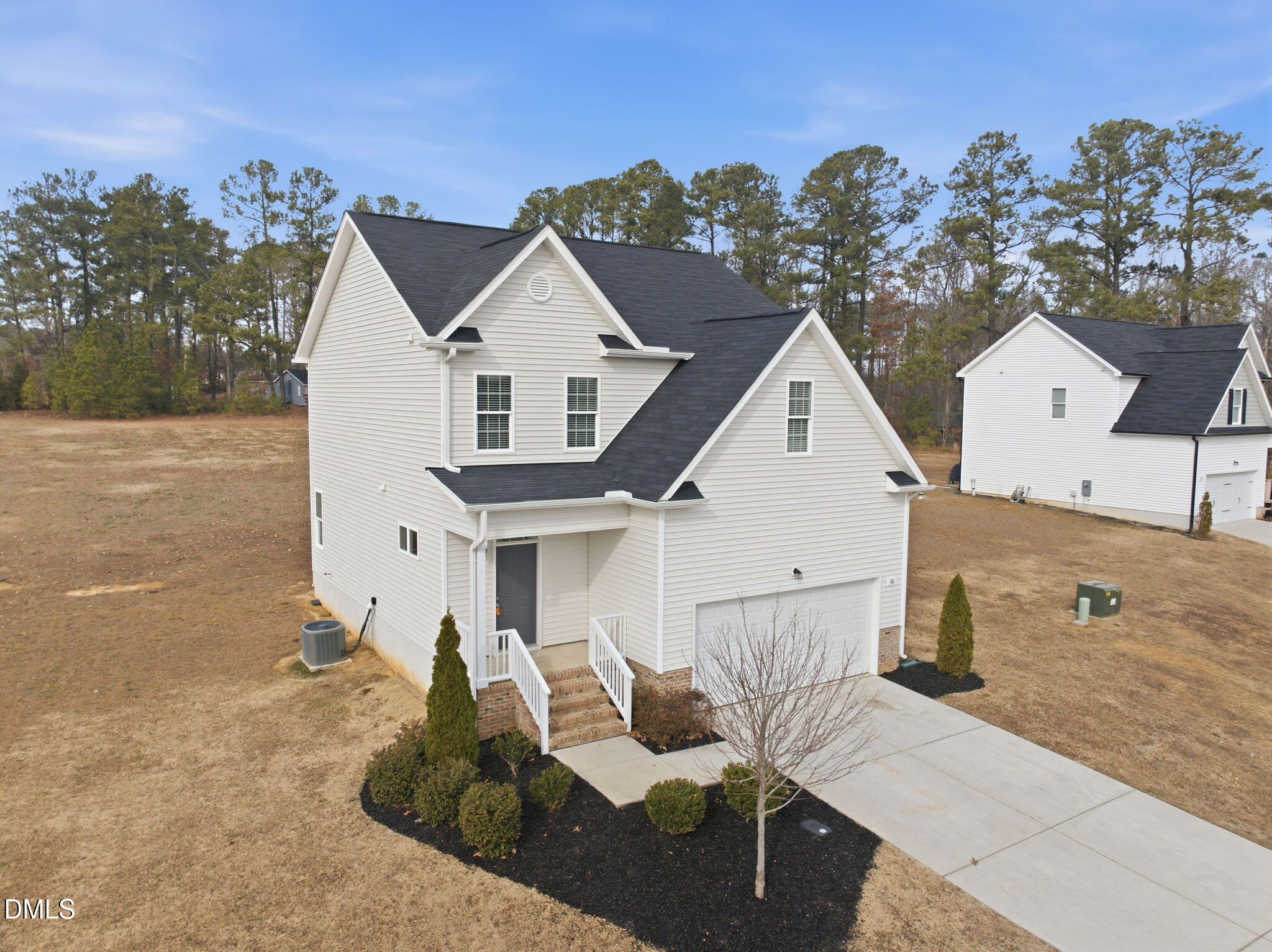 48 Weathervane Dr. Zebulon, NC 27597 - Photo 55 of 68 a view of a white house next to a yard with a fountain