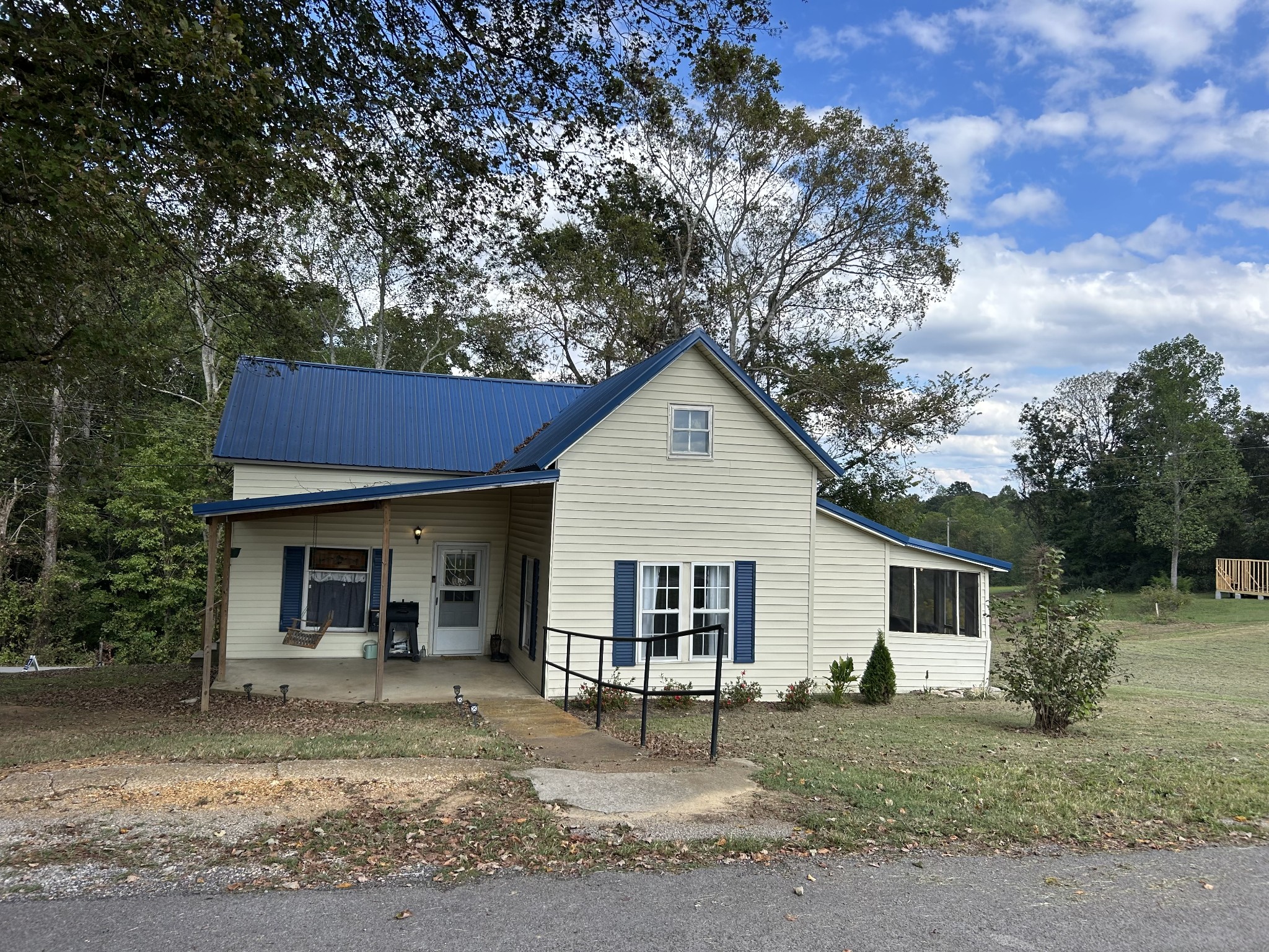 a view of a yard in front of a house with large tree