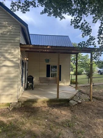 a view of a house with backyard and a tree