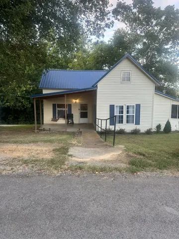 a view of a house with a yard and sitting area