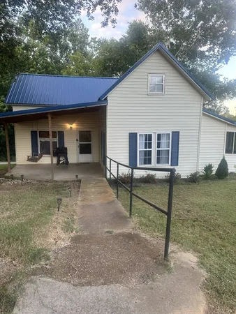 a view of a house with backyard and sitting area