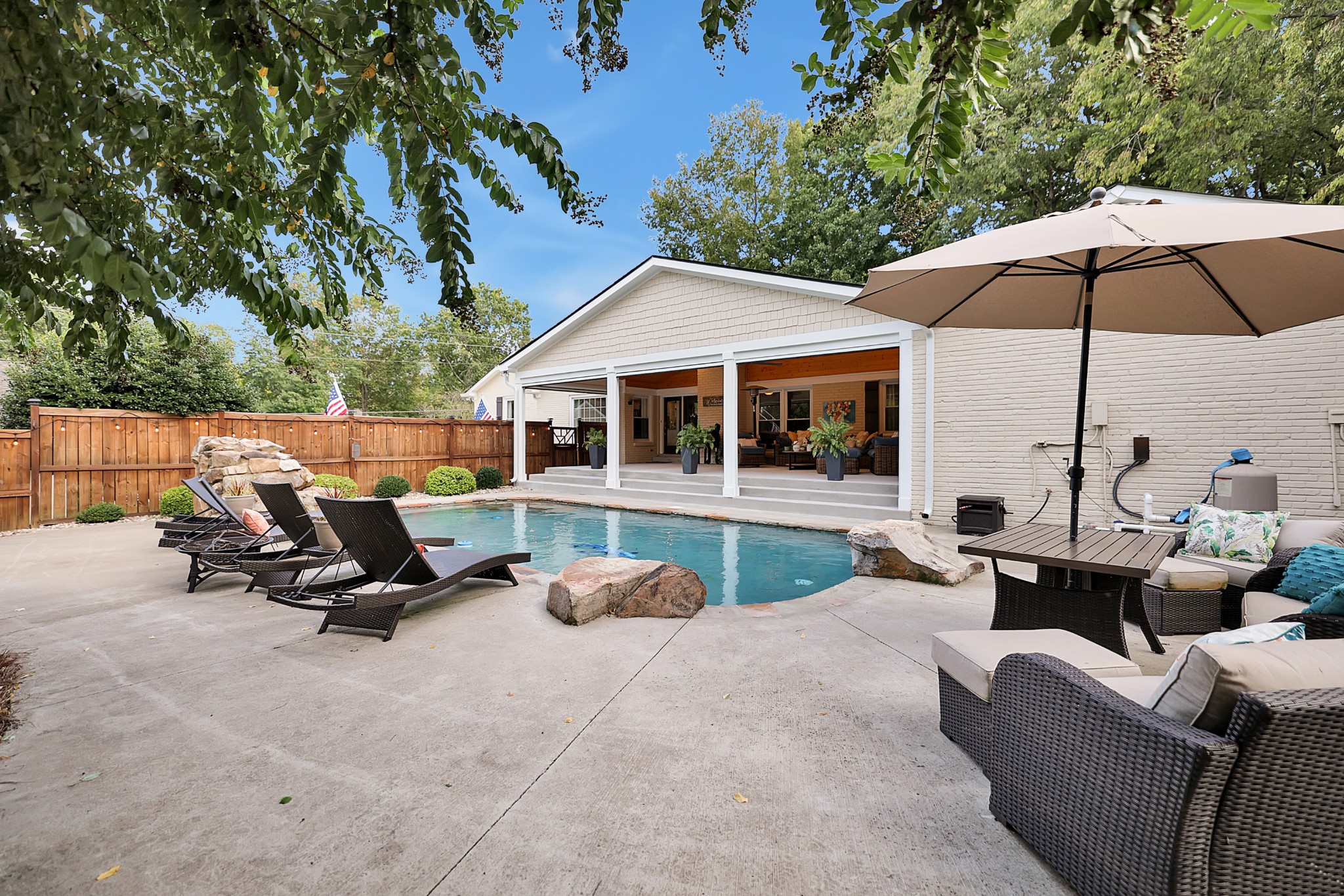 8122 Holly Road Brentwood, TN 37027 - Photo 47 of 65 a view of a patio with a table and chairs under an umbrella