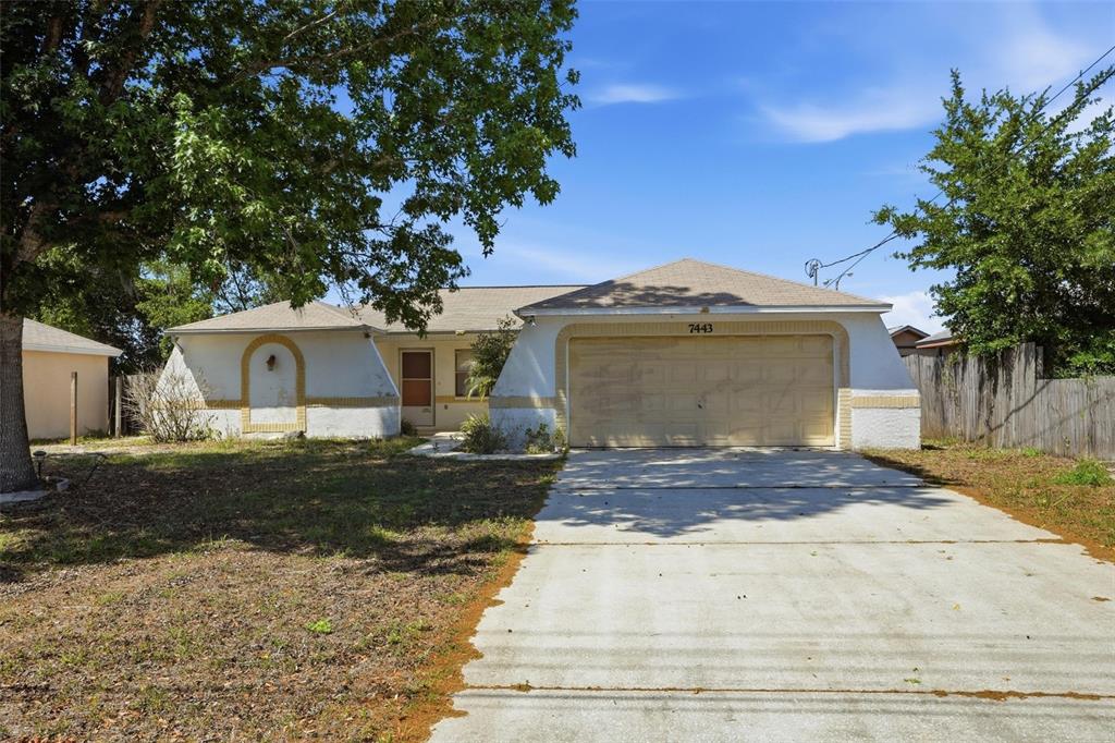 7443 Wabash Trail Spring Hill, FL 34606 - Photo 1 of 40 a front view of a house with a yard