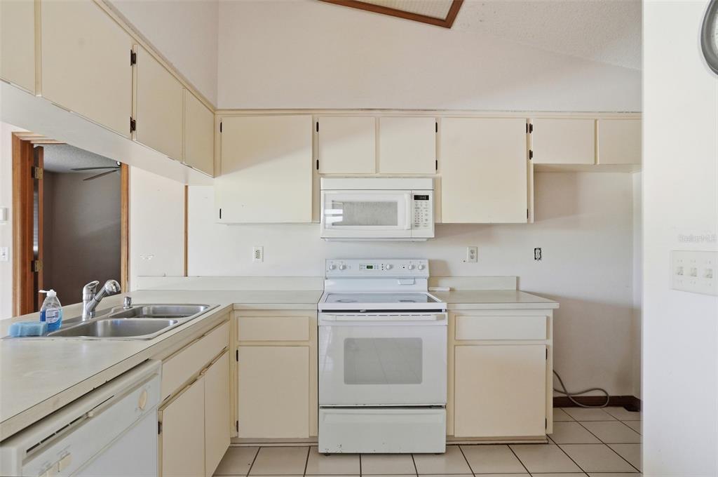 7443 Wabash Trail Spring Hill, FL 34606 - Photo 12 of 40 a kitchen with white cabinets and white appliances