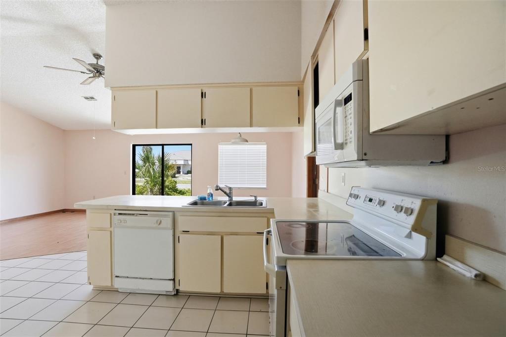 7443 Wabash Trail Spring Hill, FL 34606 - Photo 13 of 40 a kitchen with a stove oven and white cabinets