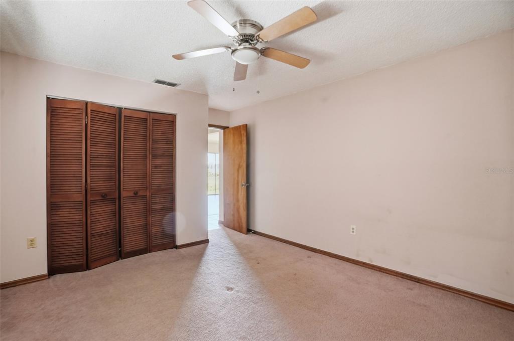 7443 Wabash Trail Spring Hill, FL 34606 - Photo 16 of 40 an empty room with windows and fan