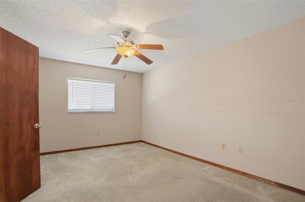 7443 Wabash Trail Spring Hill, FL 34606 - Photo 21 of 40 an empty room with a window and ceiling fan